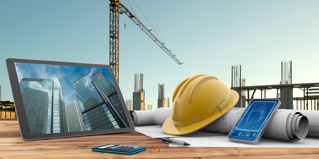 Baustellenansicht mit Laptop und Helm